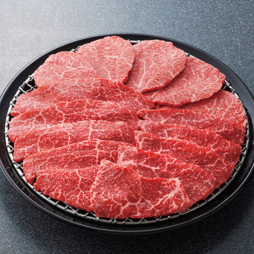 丸皿と網の上に綺麗に並べられた、美しい霜降りの入った黒毛和牛の赤身焼肉（盛り付け例）