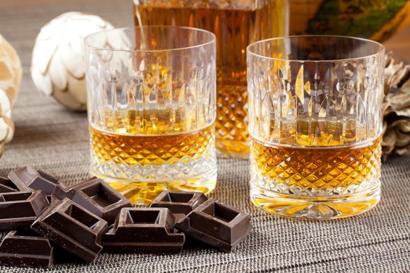 ウイスキーが入ったグラスが2つとチョコレートが置かれている。