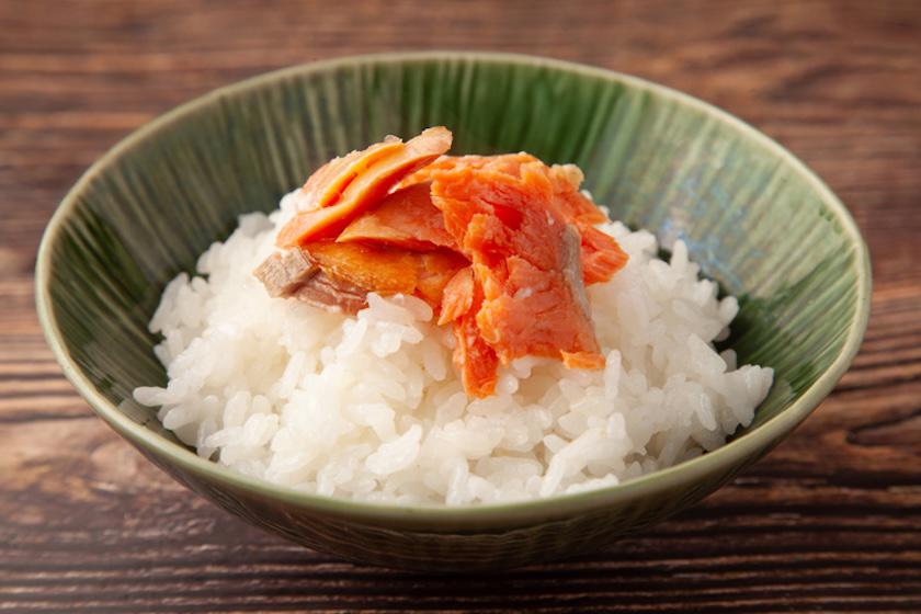 白ご飯に鮭のほぐし身がのっている。