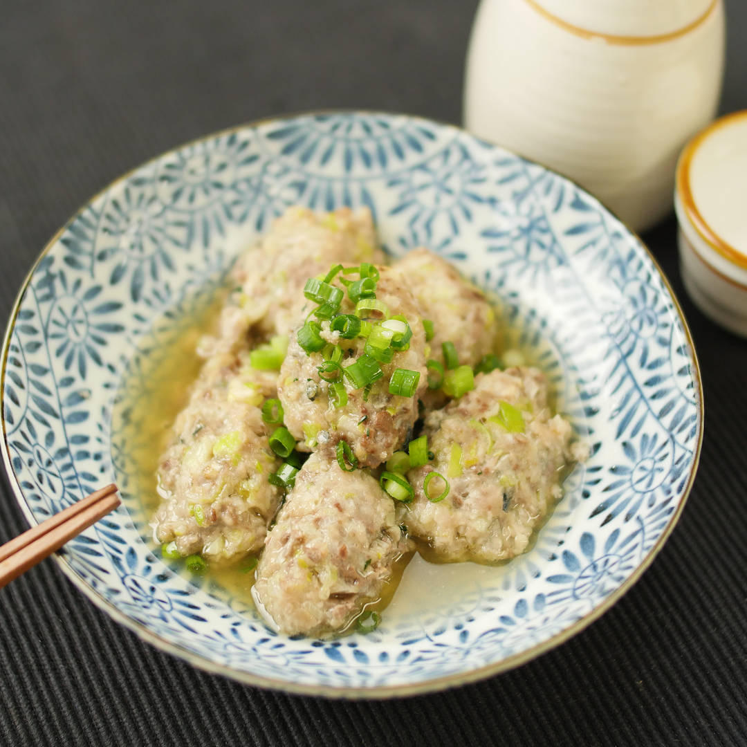 青い植物柄の皿に入ったいわしのつみれ煮