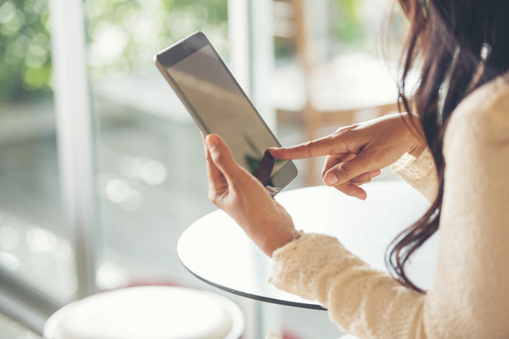 髪の長い女性がスマートフォンでリサーチをしている