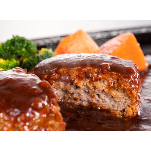 黒い皿にのったハンバーグと付け合わせのにんじん、ブロッコリー