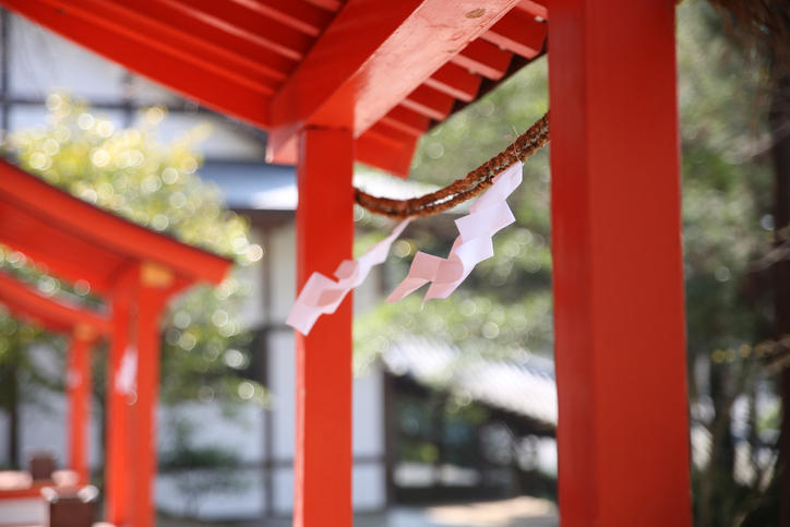 神社の朱塗りの門にしめ縄がかかっている様子