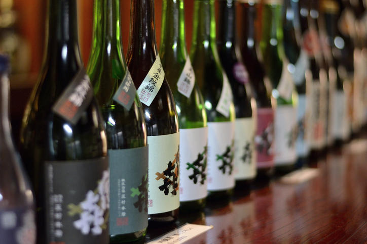 棚にさまざまな日本酒のボトルが並んでいる様子
