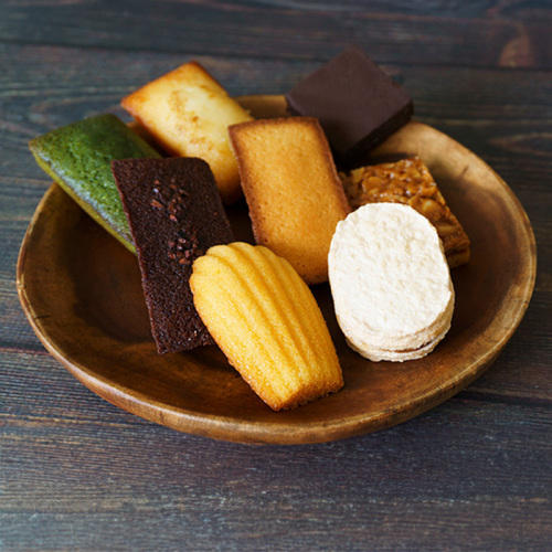 丸い木皿に「ラ・マーレ・ド・チャヤ」の焼き菓子が8個盛り合わせになっている様子