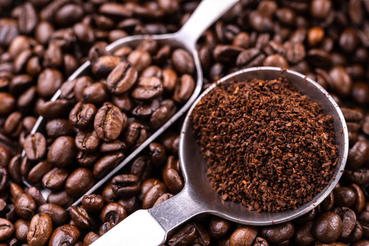 コーヒー豆とコーヒーの粉が、それぞれメジャースプーンに入っている