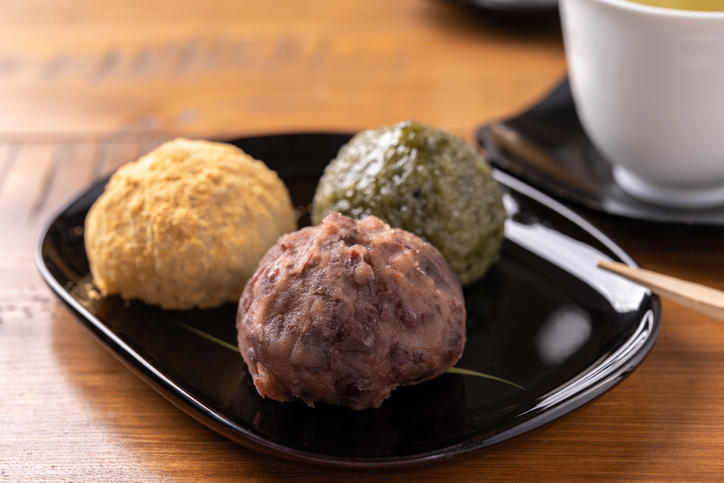 黒い皿にのった3色のおはぎと茶