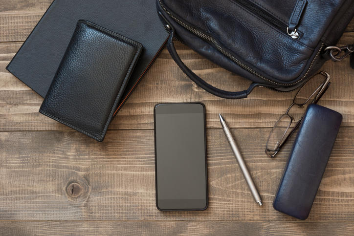 机の上に置いた財布やスマートフォン、メガネケースなどの皮製品