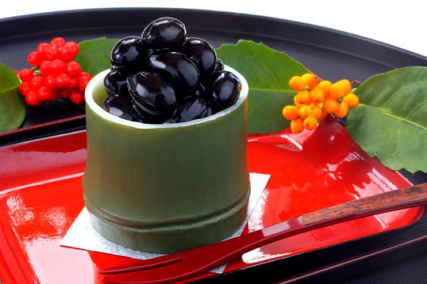 竹の器に盛り付けた黒豆の煮物