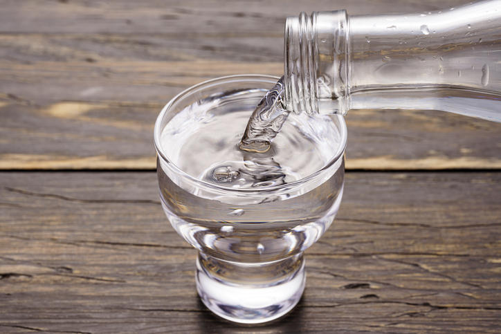 グラスに瓶入りのお酒を注ぐ様子
