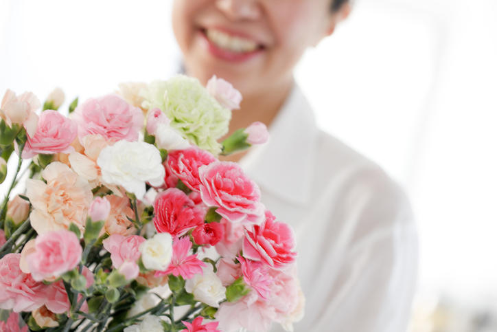 母の日に喜んで花束を受け取る女性。