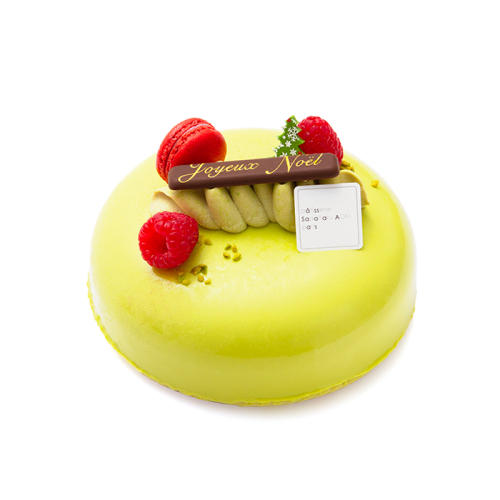 フランボワーズが飾られた、ピスタチオカラーの艶やかなケーキ。