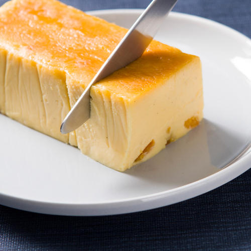 白い皿に盛られたアンドケーキのみかん入りチーズケーキ