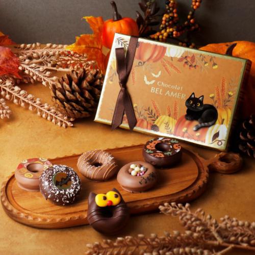 ウッドボードにハロウィンデザインのチョコレートドーナツが6個のっている。
