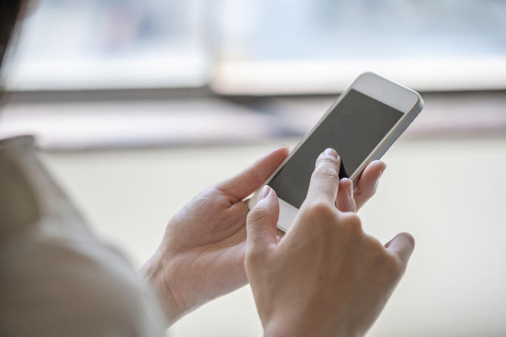 スマートフォンを操作する女性の手のアップ