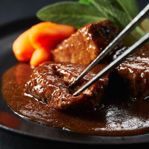 牛肉の赤ワイン煮を箸を入れようとしている。