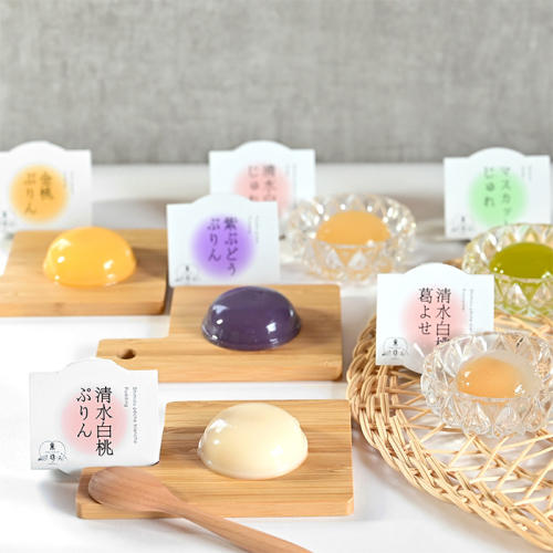 木のトレーや竹カゴの上に、「フリュテリー果坊」のぷりん・じゅれ・葛よせが並べられている様子
