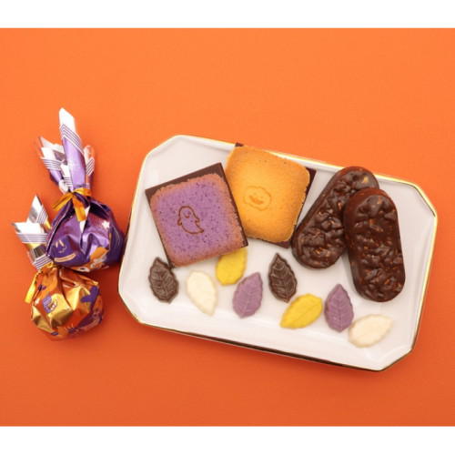 オレンジ色の背景に、ハロウィン仕様のお菓子が置かれている。