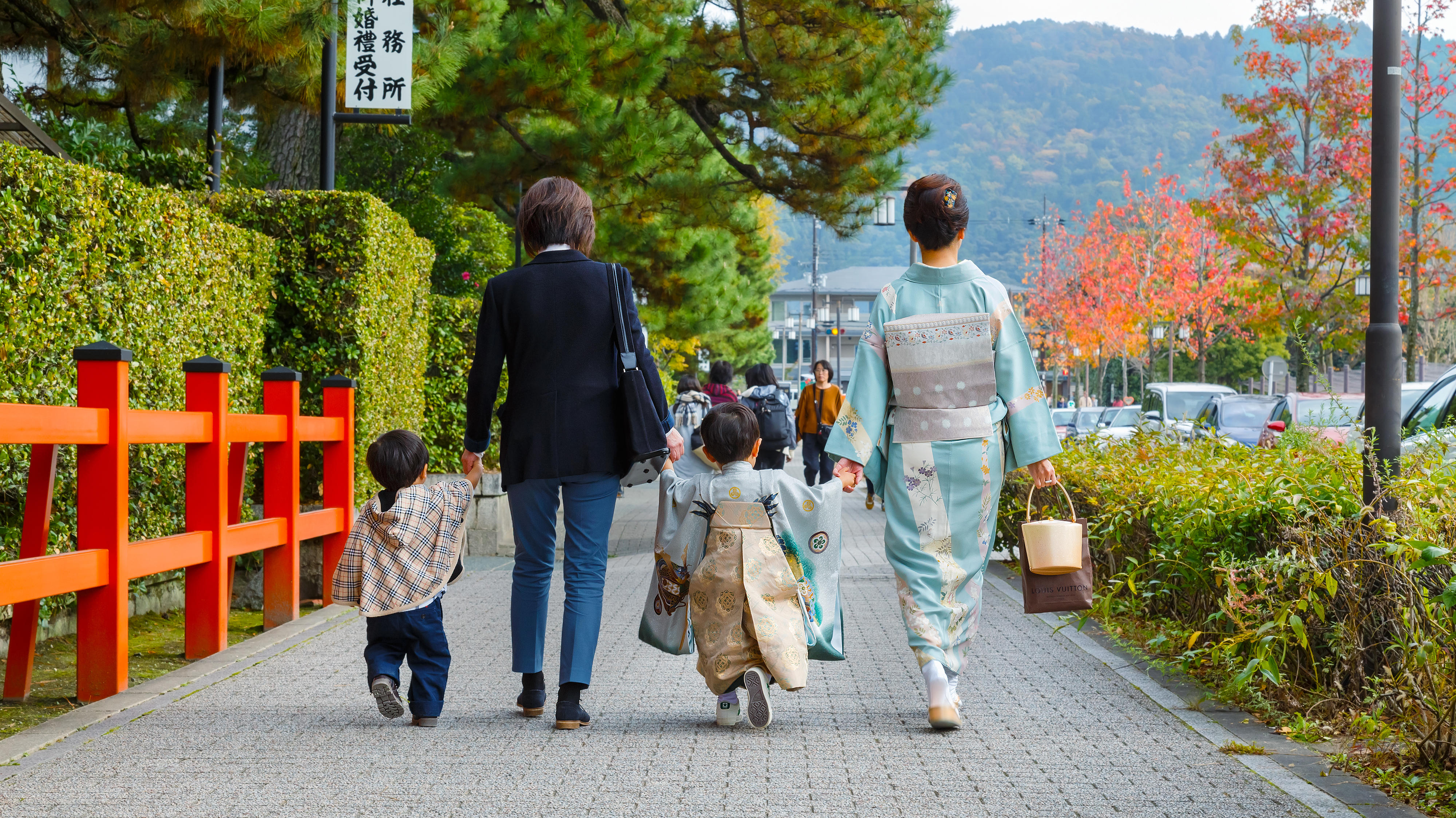 晴れ着を着て手をつないで歩く家族の様子