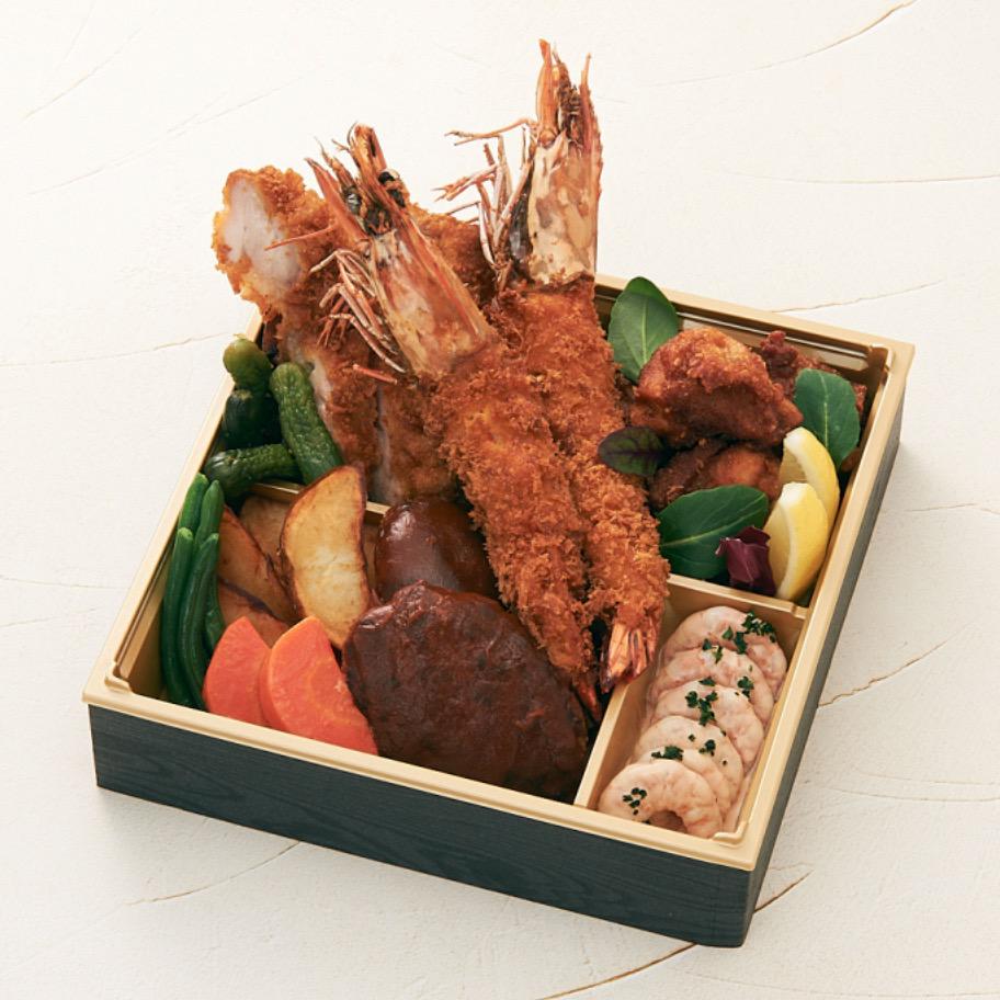 黒と金の弁当箱に入ったエビフライやハンバーグの弁当