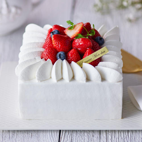 いちごとブルーベリーがのったスクエア型の白いケーキ。