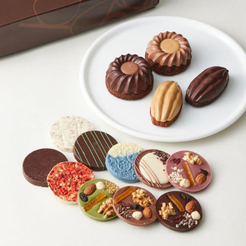 円形の板チョコ10枚と焼き菓子5個が置かれている。
