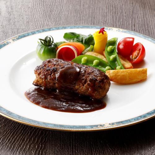 ハンバーグと野菜が盛りつけられた白色の皿。