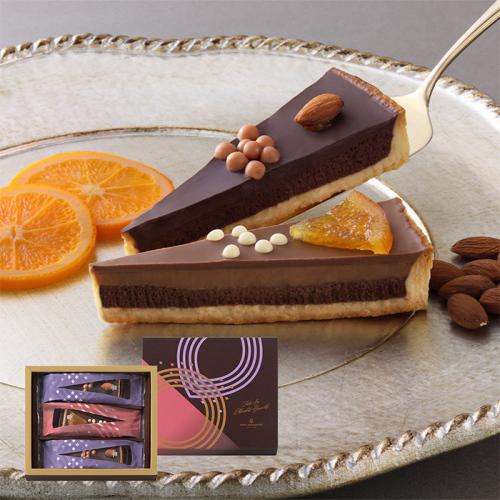シルバーの皿にチョコタルト2個、スライスされたオレンジ、アーモンドがのっている。