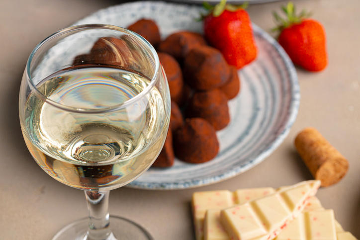 白ワインが注がれたグラスとお皿に盛られたトリュフチョコレート