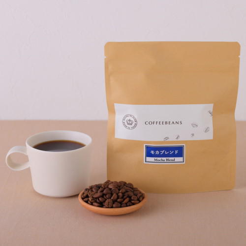 ロイヤルフレーバーのモカブレンドのパッケージと皿に盛られた豆、白いカップに注がれたコーヒー