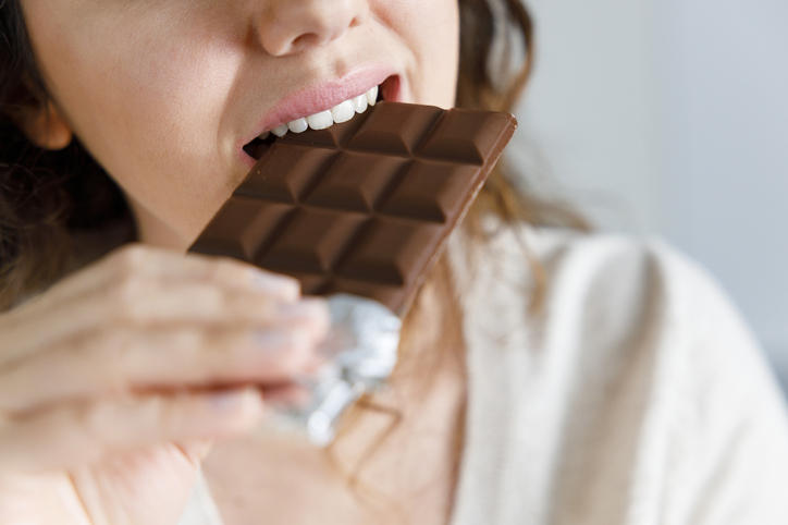板チョコレートを食べる女性