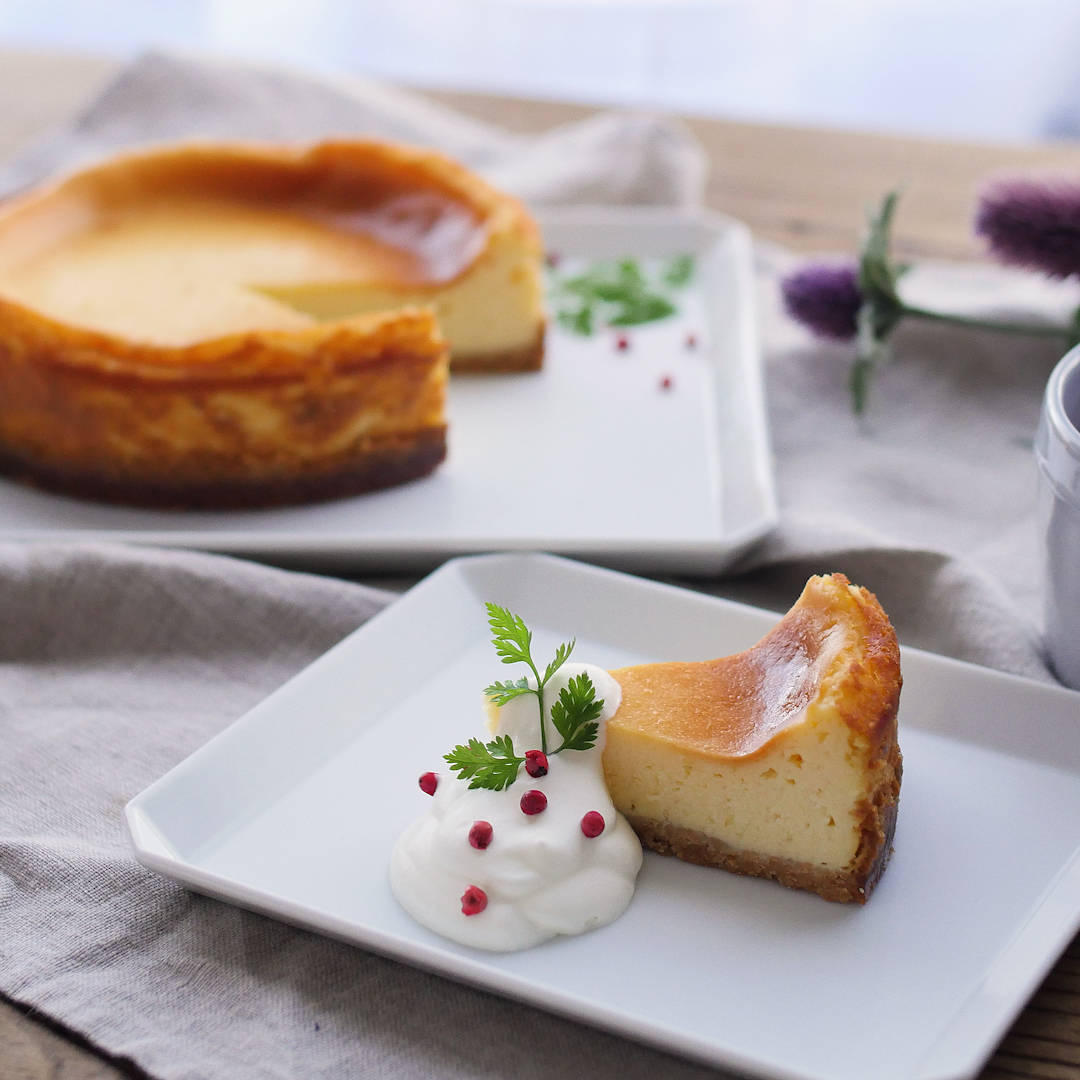 クリームが添えられたベイクドチーズケーキ