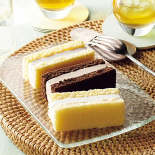 中央にスポンジケーキのアイスサンドが3つ置かれ、周りにフォークやお茶が置かれている。