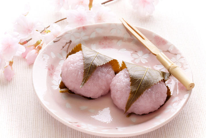 ピンク色の皿に盛られた2個の桜餅と菓子楊枝