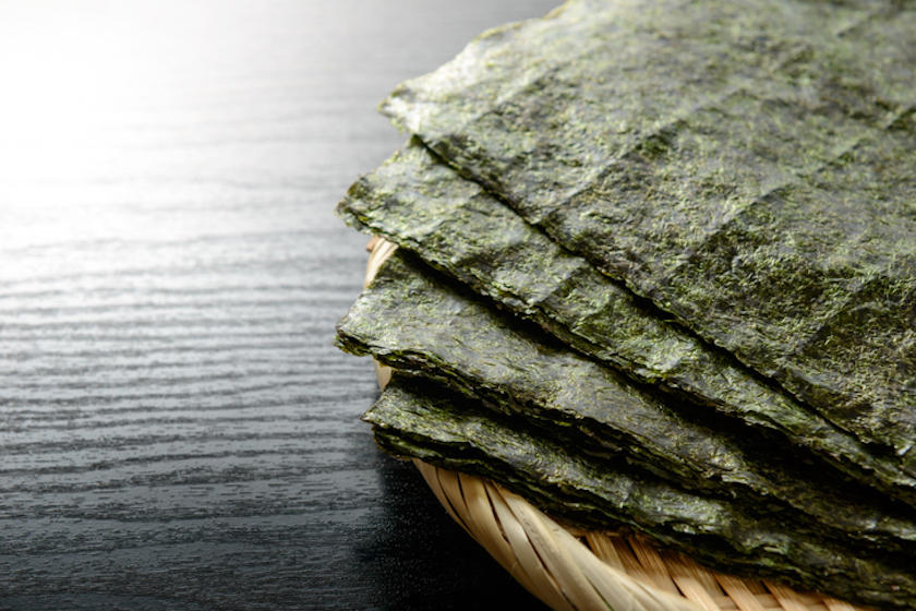 黒色のテーブルに、焼き海苔がのった竹ざるが置かれている。