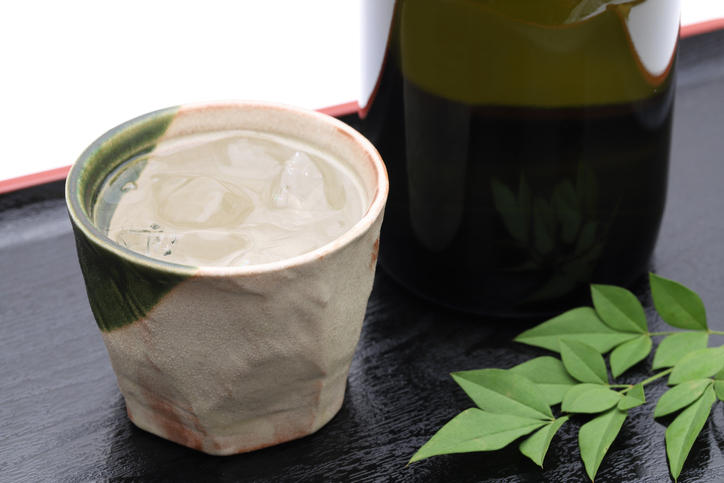 焼酎が入った陶器のコップとボトルが置かれている