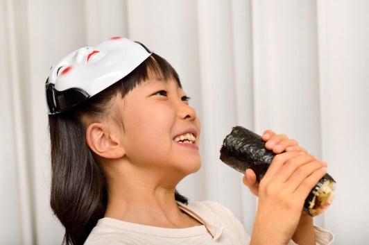 女の子が恵方巻きを食べようとしている様子