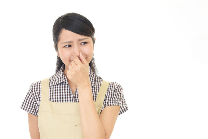 鼻をつまんでいる女性