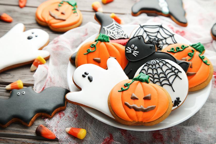 木製テーブルの上に、ハロウィンのアイシングクッキーがのった皿が置かれている。