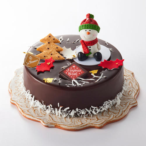 雪だるまの飾りがのったホールサイズのチョコレートケーキ。