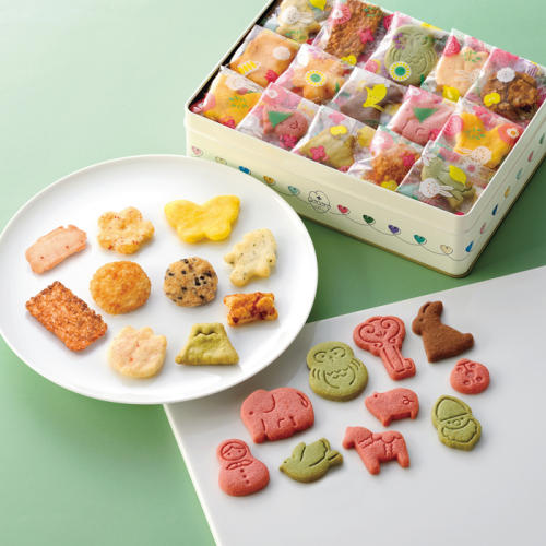 カラフルなおかきとクッキーがのった皿と、詰め合わせ缶が置かれている。