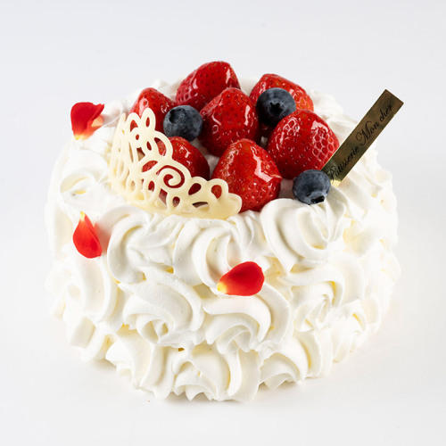 いちご、ブルーベリー、バラの花びら、チョコ細工のティアラがのったホールサイズのケーキ。