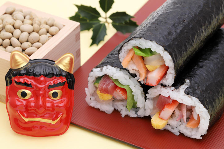 恵方巻が3本と、鬼の仮面、枡に入った節分豆が置かれている