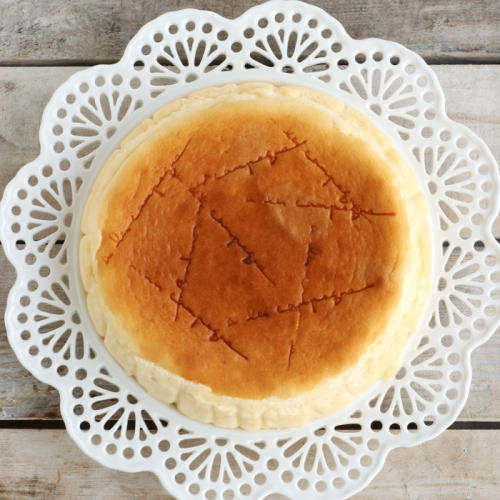 レースペーパーの上にのせた、焼き印の入ったスフレチーズケーキ