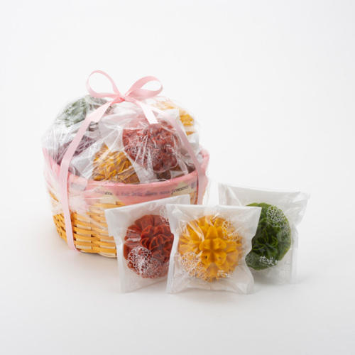 ピンクのリボン付きのかごに入れられたお花の形をしたかりんとう菓子