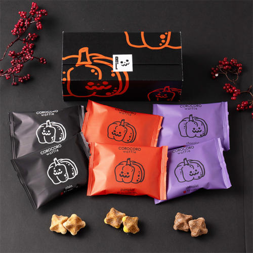 黒色の背景に、ハロウィンのかぼちゃがデザインされたパッケージのお菓子が置かれている。