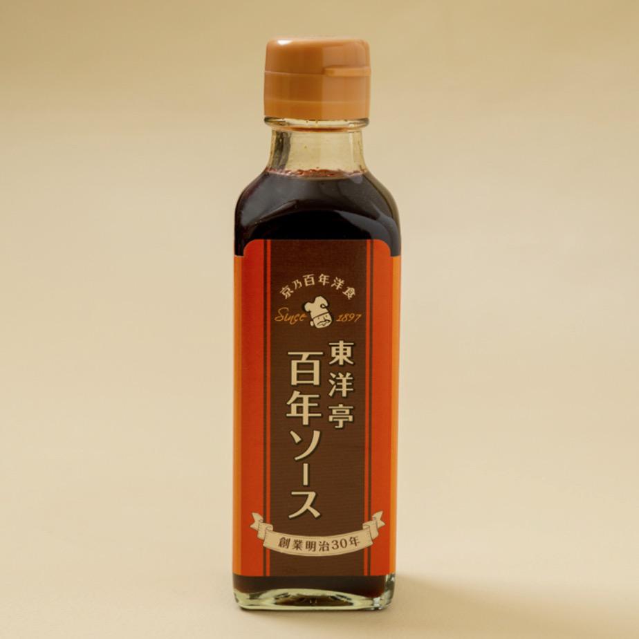 グレージュの背景に置かれた瓶入りソース
