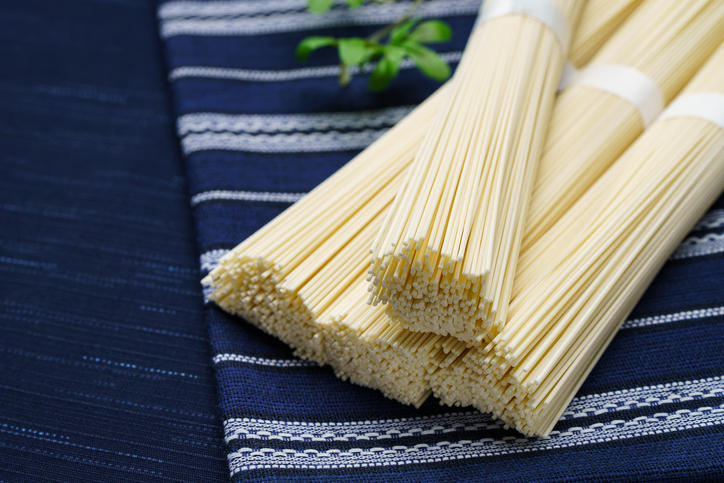 藍色の織物の上に置かれた乾燥素麺の束