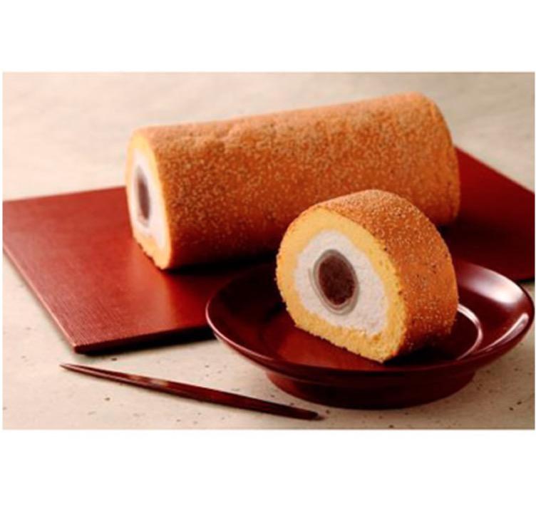 赤い長方形の皿に乗った1本のロールケーキと赤い丸皿の上の1切れのロールケーキ