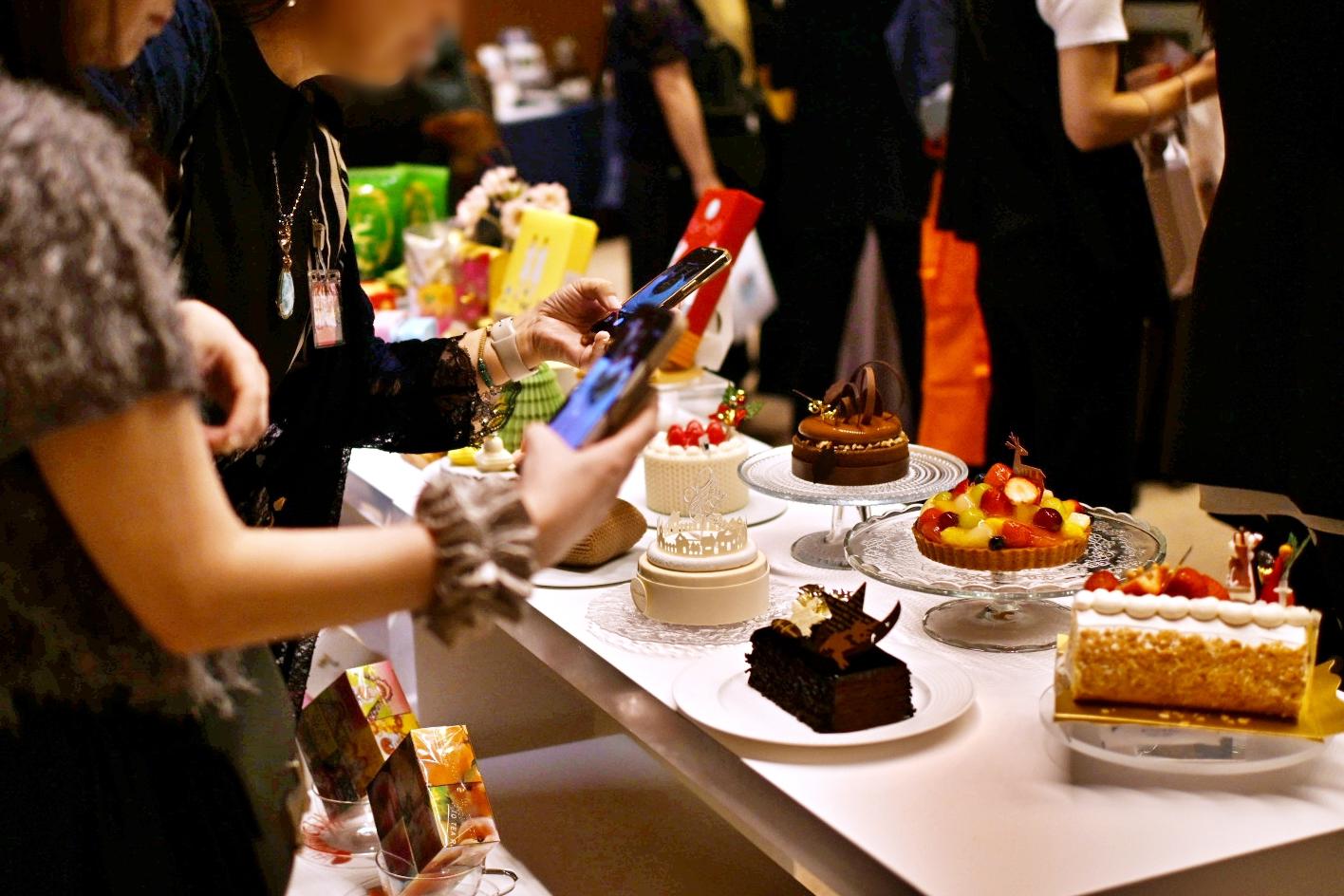 今年のクリスマスケーキをお披露目。ケーキを写真におさめるサポーターたちの様子